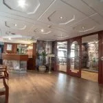 The sophisticated lobby of the Sonesta Nile Goddess Cruise​ with a polished wooden reception desk and a staircase leading to the upper deck.