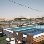 The MS Nile Goddess Nile Cruise swimming pool with the beautiful Nile River and desert landscape in the background.