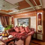 Ms Sonesta St George Nile Cruise cabin featuring a luxurious living area with a plush red sofa and a separate bedroom.