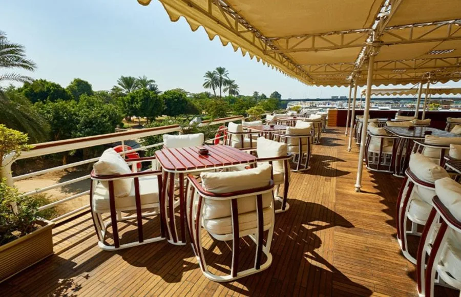 A stunning photo of the dining deck on the MS Sonesta St. George Nile Cruise ship, showcasing comfortable seating and beautiful views of the Nile River.