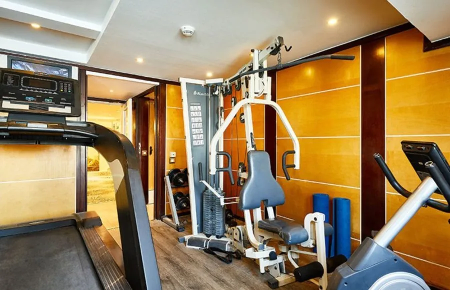 The compact and well-equipped gym on the MS Sonesta St George Nile Cruise, featuring a treadmill, weight machine, and other fitness equipment for guests to use while on board.