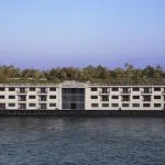 The Sonesta Star Goddess Nile cruise ship sailing on the Nile River, showcasing its multi-story design and numerous balconies for passengers.