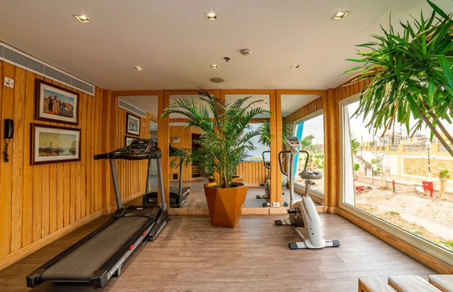 The well-equipped gymnasium on the MS Sonesta Sun Goddess Nile River Cruise, featuring a treadmill, exercise bike, and large windows.