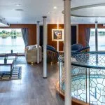The elegant lounge on the Sonesta Sun Goddess Nile cruise ship, with comfortable seating and large windows overlooking the beautiful Nile River.