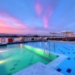 The swimming pool on the MS Steigenberger Minerva cruise ship at sunset.