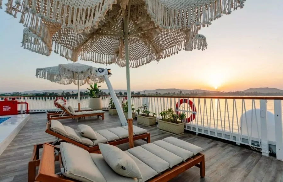 The beautiful sun deck of the Tamr Henna Nile Cruise Ship features stylish lounge chairs and macrame umbrellas offering the perfect vantage point for a stunning Nile sunset