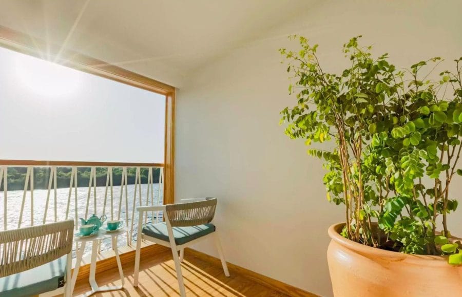 The private cabin terrace on the Tamar Henna nile cruise offers stunning sunlit views of the river from comfortable chairs perfect for enjoying a morning tea or coffee