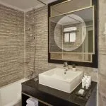 A modern, well-appointed bathroom on the MS Tulip Nile Cruise featuring a bathtub, contemporary vanity, stylish mirror, and textured wall tiles.