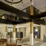 The luxurious, modern lobby and reception area of the MS Tulip Nile Cruise features gold pillars, stylish seating, and panoramic windows overlooking the river.