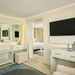 A view of a luxurious, elegantly decorated suite on the Tulip Nile Cruise, featuring modern furnishings, a dressing area, and a television.