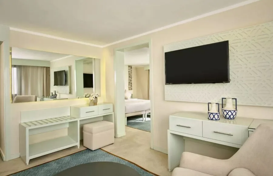 A view of a luxurious, elegantly decorated suite on the Tulip Nile Cruise, featuring modern furnishings, a dressing area, and a television.