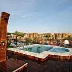 The swimming pool on the sun deck of the MS Mayfair Nile Cruise with a view of an ancient temple.
