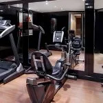 The modern gym on the Moondance Nile Cruise, featuring a treadmill, exercise bike, and other fitness equipment with a mirrored wall, allowing guests to stay active during their voyage.
