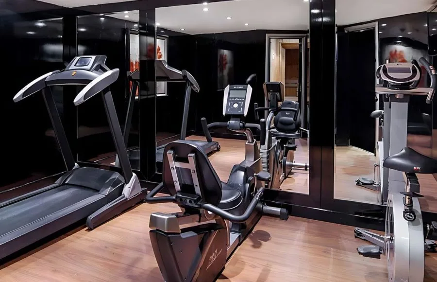 The modern gym on the Moondance Nile Cruise, featuring a treadmill, exercise bike, and other fitness equipment with a mirrored wall, allowing guests to stay active during their voyage.