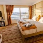 Nebu Nile Cruise suite with Nile view, large bed, and TV.