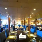 The elegant dining room on the Blue Shadow 4, with tables and plush chairs.