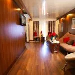 A luxurious suite on the Blue Shadow IV, featuring a living area with a stylish sofa and modern wooden decor.