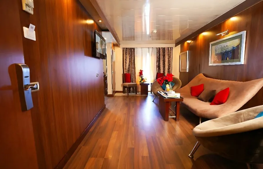 A luxurious suite on the Blue Shadow IV, featuring a living area with a stylish sofa and modern wooden decor.