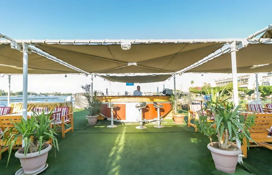 An outdoor bar and lounge area on the sun deck of the Blue Shadow IV, with a covered canopy and comfortable seating.