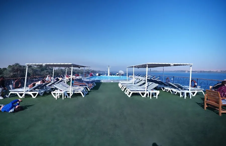 The spacious sun deck of the Blue Shadow 4 Nile Cruise, featuring rows of sun loungers and a view of the Nile River.