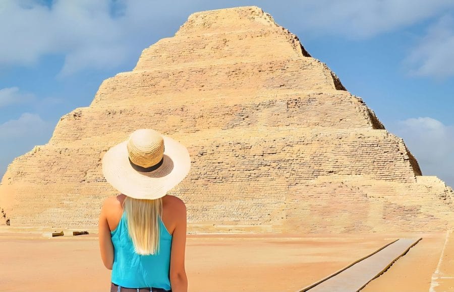 Saqqara-Egypt-A-blonde-Haired-Woman-Stands-In-Front-of-The-Oldest-Standing-Step-Pyramid-in-Egypt -Tripidays-Egypt-Tour