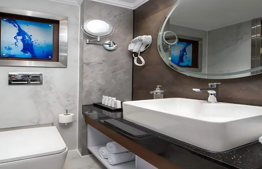 A contemporary and elegant bathroom aboard the Sindbad Nile Cruise, featuring a sleek basin, modern mirror, and a calming blue artwork.