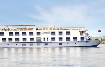 The elegant H/S Sindbad Nile Cruise sails smoothly along the majestic river, a symbol of luxury travel and adventure in Egypt.