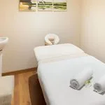A tranquil spa treatment room aboard the Sindbad Nile Cruise, featuring a massage table, sink, and calming artwork.