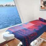 The serene spa treatment room on the Kon Tiki Nile cruise with a massage table and a stunning window view of the river.