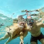 A-young-couple-is-snorkeling-selfie-with-an-underwater-camera-on-the-coral-reef-in-Hurghada