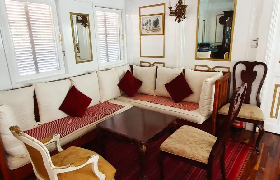 Air-conditioned lounge with sofas and chairs on the Abundance Dahabiya Nile cruise ship.