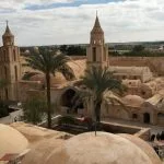 Aerial view of the historic Anba Beshoy Monastery in Wadi El Natrun with its traditional architecture and twin bell towers.