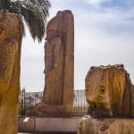 Monumental statues of Pharaoh Ramesses II standing at the ruins of ancient Memphis, Egypt.