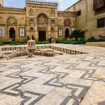 The patterned marble courtyard and ornate entrance facade of the Coptic Museum in Cairo.