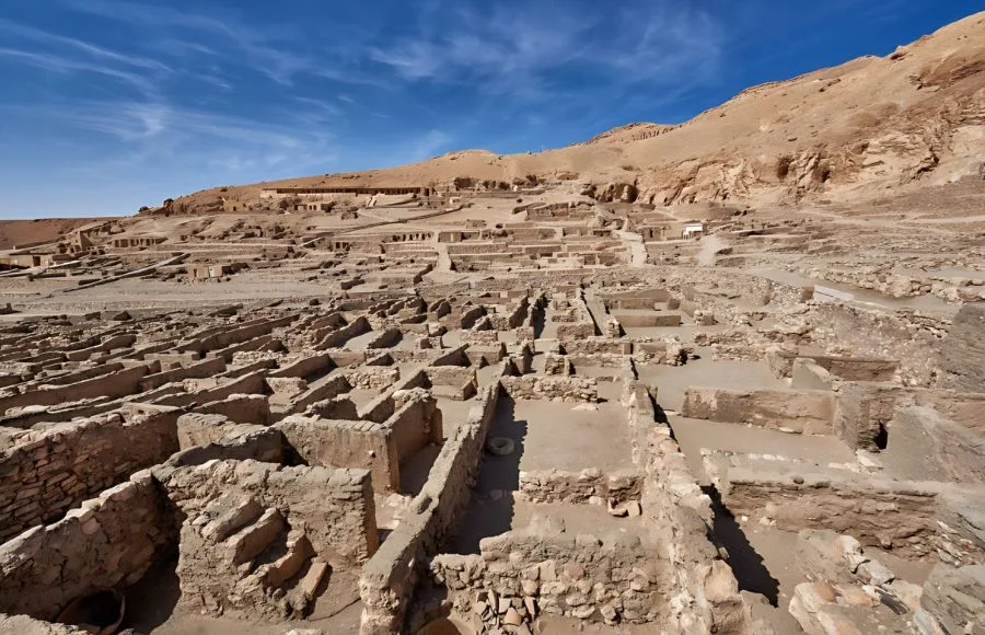A wide View of Deir el-Medina ancient Egyptian village Luxor Egypt showing the extensive stone and mud-brick foundations of the homes of the workers who built the tombs in the Valley of the Kings.