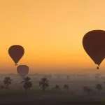 Hot-Air-Balloons-Flying-At-Dawn-Over-The-Desert-Near-Luxor