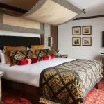 An elegant, traditionally furnished hotel suite bedroom on a Nile cruise boat.