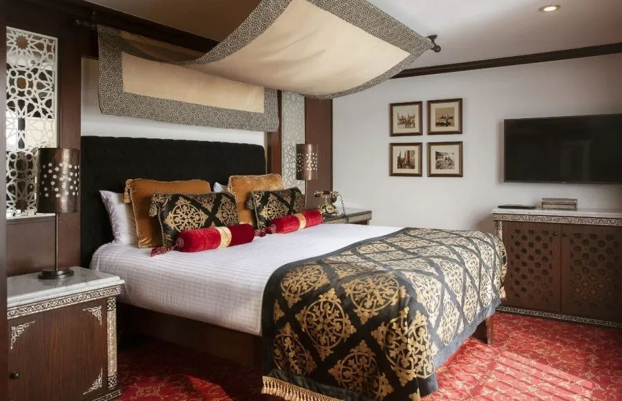 An elegant, traditionally furnished hotel suite bedroom on a Nile cruise boat.