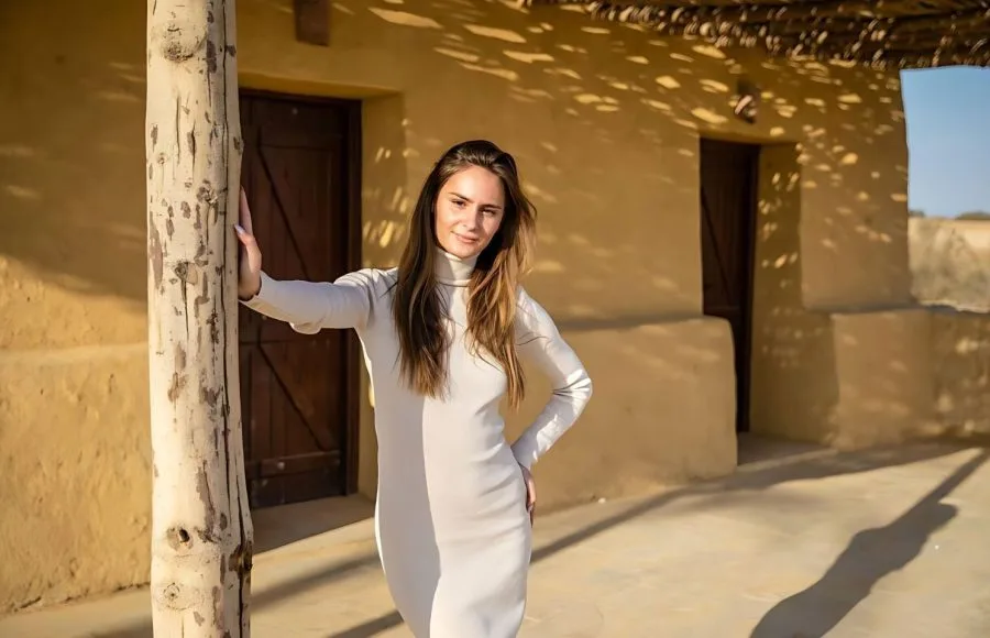 Lady posing in front of a traditional mud-brick structure at Wadi El Rayan in the Western Desert, Egypt.