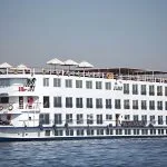 A full exterior shot of the white MS A Sara cruise ship sailing on the Nile River, showcasing its multi-deck design.