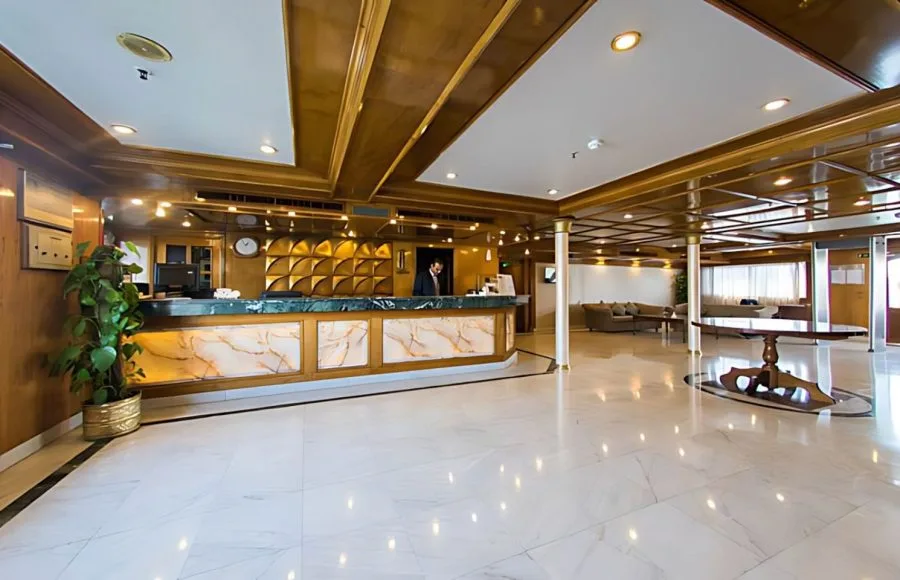 The reception of the A Sara Nile Cruise features a marble-topped counter, polished floors, and elegant wooden paneling.