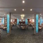 Elegant cruise ship lounge with armchairs, sofas, and illuminated pillars.