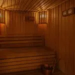 A warm and inviting sauna room on the Jaz Senator Nile Cruise, featuring wooden benches and walls, and soft lighting.