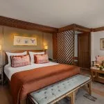 A luxurious suite on the Jaz Senator Nile Cruise, featuring a king-sized bed with rich fabrics, a seating area, and traditional Egyptian-inspired decor.