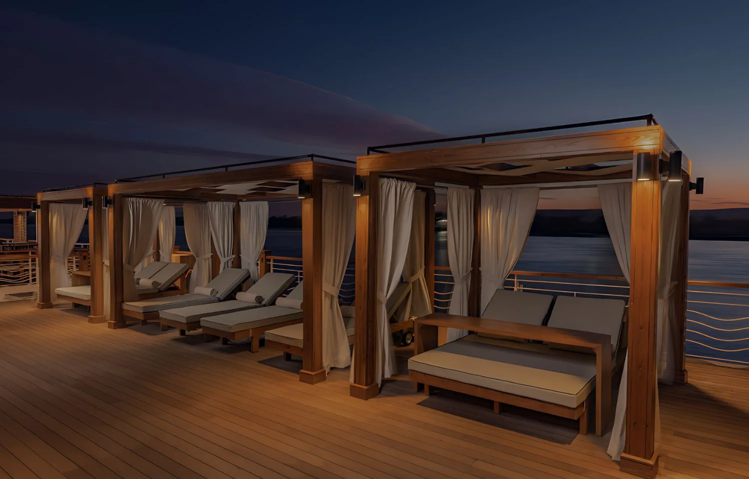 The sun deck of the Jaz Senator Nile Cruise at night, illuminated with soft lights, showing private cabanas with lounge beds overlooking the serene Nile.