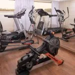 A modern gymnasium on the MS Jaz Viceroy Nile Cruise with various workout equipment, including treadmills, an elliptical, a stationary bike, and a rowing machine.