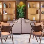 The elegant reading area on the MS Jaz Viceroy Nile Cruise, featuring comfortable chairs, a sofa, and shelves filled with books.