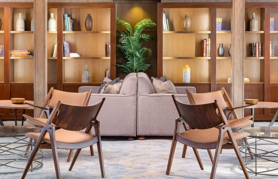 The elegant reading area on the MS Jaz Viceroy Nile Cruise, featuring comfortable chairs, a sofa, and shelves filled with books.