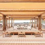 A view of the upper deck lounge of the MS Jaz Viceroy Nile Cruise, with a large, comfortable daybed-style seating area in the center and other lounge furniture around it.
