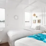 Bright twin-bed cabin on a Dahabiya Nile cruise with large windows overlooking the river.